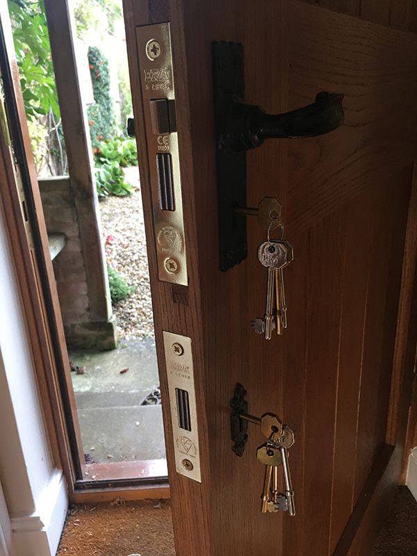 Lock installations and repairs that have been carried out on a wooden front door.